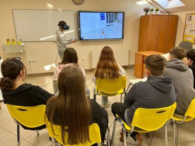 uczniowie obserwują kolegę, który wykonuje doświadczenie z wykorzystaniem Empiriusza