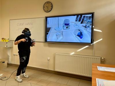 chłopiec w goglach VR i kontrolerach wykonuje doświadczenie za pomocą Empiriusza