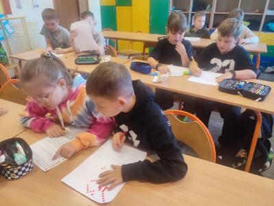 Uczniowie dekodują dyktando graficzne