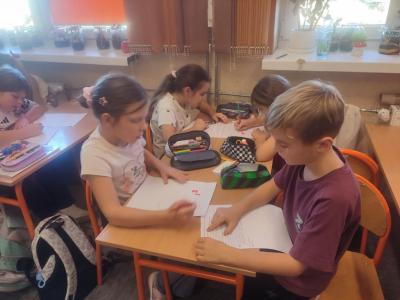 Uczniowie dekodują dyktando graficzne