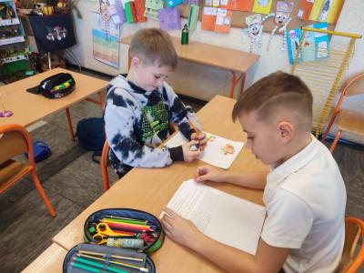 Uczniowie dekodują dyktando graficzne