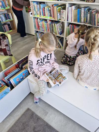 Dziewczynka siedzi i ogląda książkę