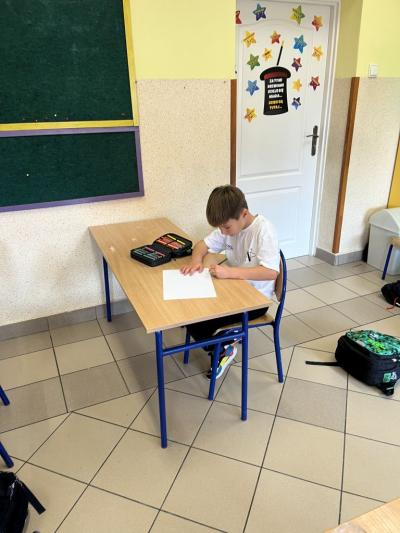 chłopiec na szkolnej świetlicy rysuje gołębicę