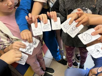 dzieci trzymają karteczki ze zwierzątkami