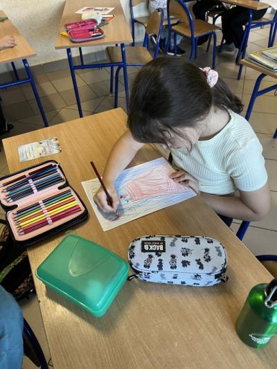 dziewczynka rysuje ilustrację do opowiadania o gołębicy Cher Ami