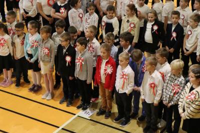 Uczniowie i zaproszeni goście obserwują występ na scenie