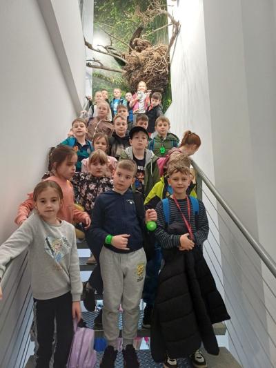 uczniowie stoją na schodach, a nad nimi gniazdo orła