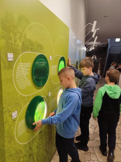 Uczniowie w muzeum przyrodniczym korzystają z interaktywnych eksponatów i przyrządów