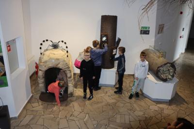 Uczniowie w muzeum przyrodniczym korzystają z interaktywnych eksponatów i przyrządów