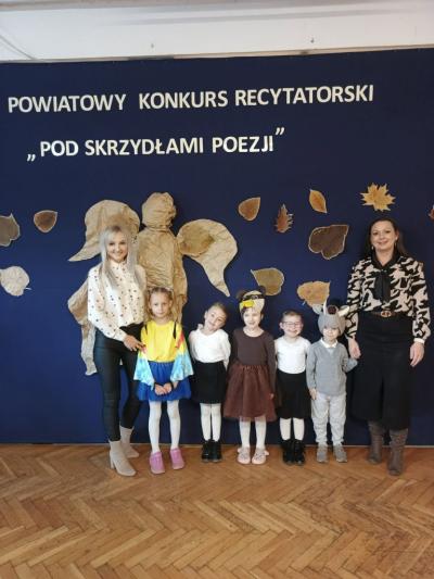 Grupa przedszkolaków stojących z nauczycielkami