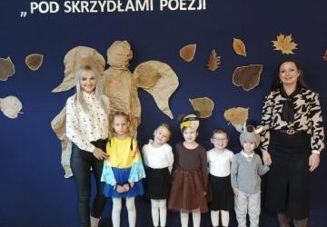 Grupa przedszkolaków stojących z nauczycielkami