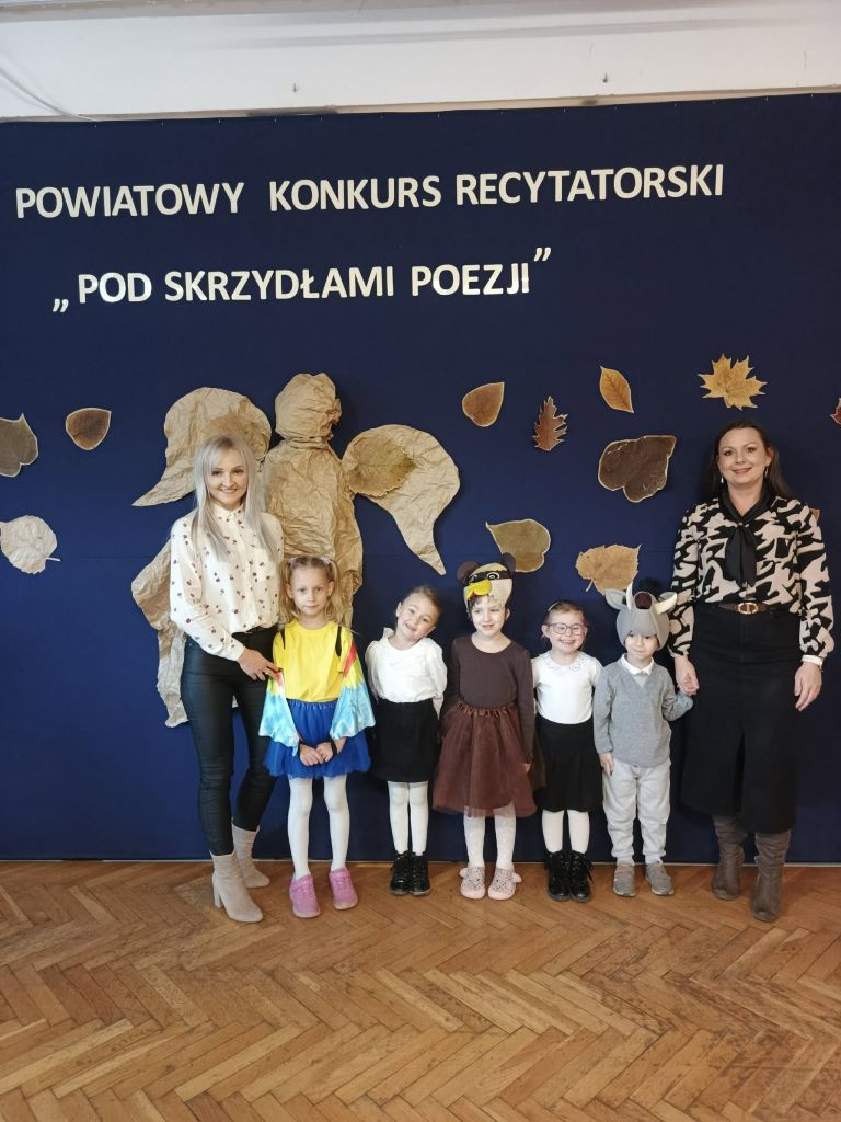 Grupa przedszkolaków stojących z nauczycielkami