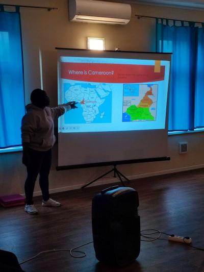 Wolontariusz przedstawiający swój kraj na prezentacji multimedialnej.