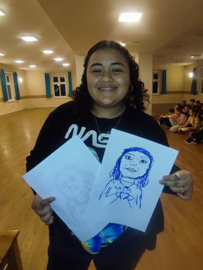 Wolontariusz prezentujący karykaturę wykonaną przez uczestników obozu EuroWeek