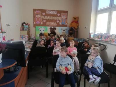 Uczniowie siedzą w czytelni i oglądają film o bajkowych misiach.