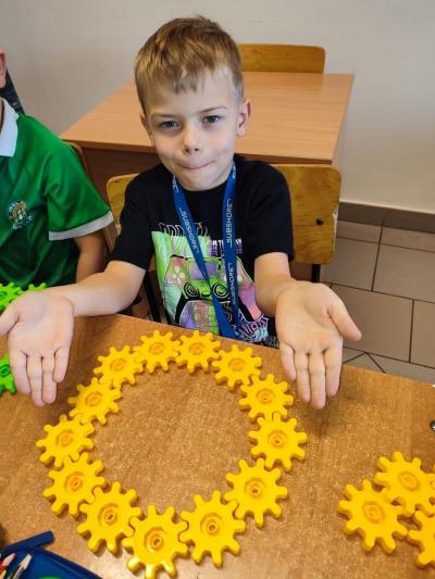 Uczniowie układają wylosowane figury geometryczne i obliczają ile zawierają elementów.