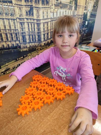 Uczniowie układają wylosowane figury geometryczne i obliczają ile zawierają elementów.