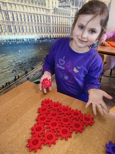 Uczniowie układają wylosowane figury geometryczne i obliczają ile zawierają elementów.