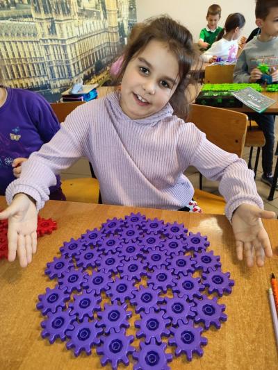 Uczniowie układają wylosowane figury geometryczne i obliczają ile zawierają elementów.