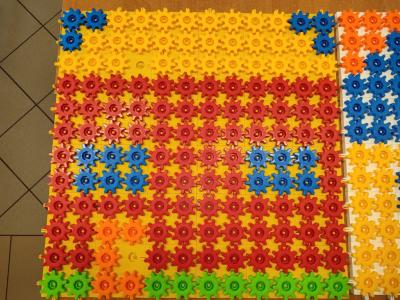 Uczniowie układają domek z różnych figur geometrycznych.