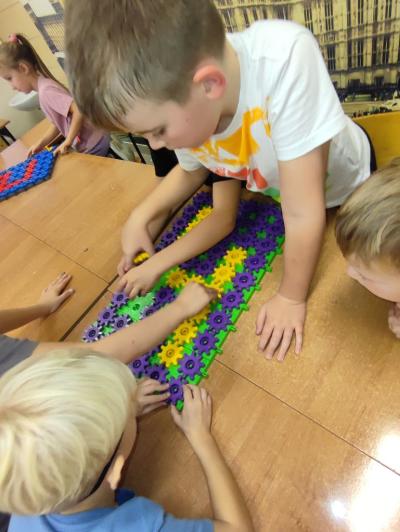 Uczniowie układają cyfry z klocków