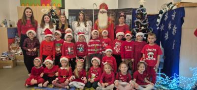 Grupa Biedronki pozuje do zdjęcia z Mikołajem.