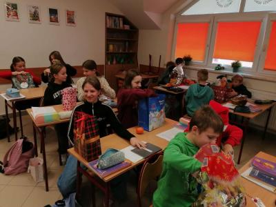 Uczniowie otrzymują i rozpakowywują prezenty od Świętego Mikołaja