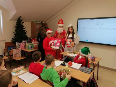 Uczniowie otrzymują i rozpakowywują prezenty od Świętego Mikołaja