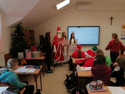Uczniowie otrzymują i rozpakowywują prezenty od Świętego Mikołaja