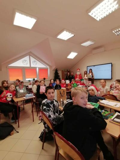 Uczniowie otrzymują i rozpakowywują prezenty od Świętego Mikołaja