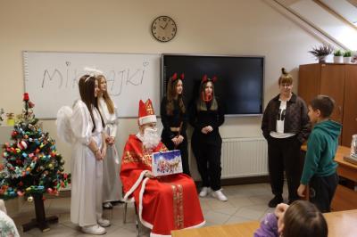 Uczniowie otrzymują i rozpakowywują prezenty od Świętego Mikołaja