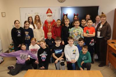 Uczniowie otrzymują i rozpakowywują prezenty od Świętego Mikołaja