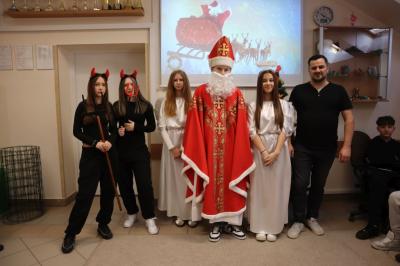 Święty Mikołaj z dwoma aniołkami, nauczycielem i diabełkiem pozują do zdjęcia.