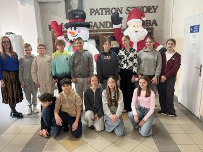 klasa 6b wraz z wychowawczynią stoją na korytarzu szkolnym - z tyłu dmuchany mikołaj i bałwan