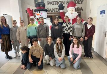 klasa 6b wraz z wychowawczynią stoją na korytarzu szkolnym - z tyłu dmuchany mikołaj i bałwan