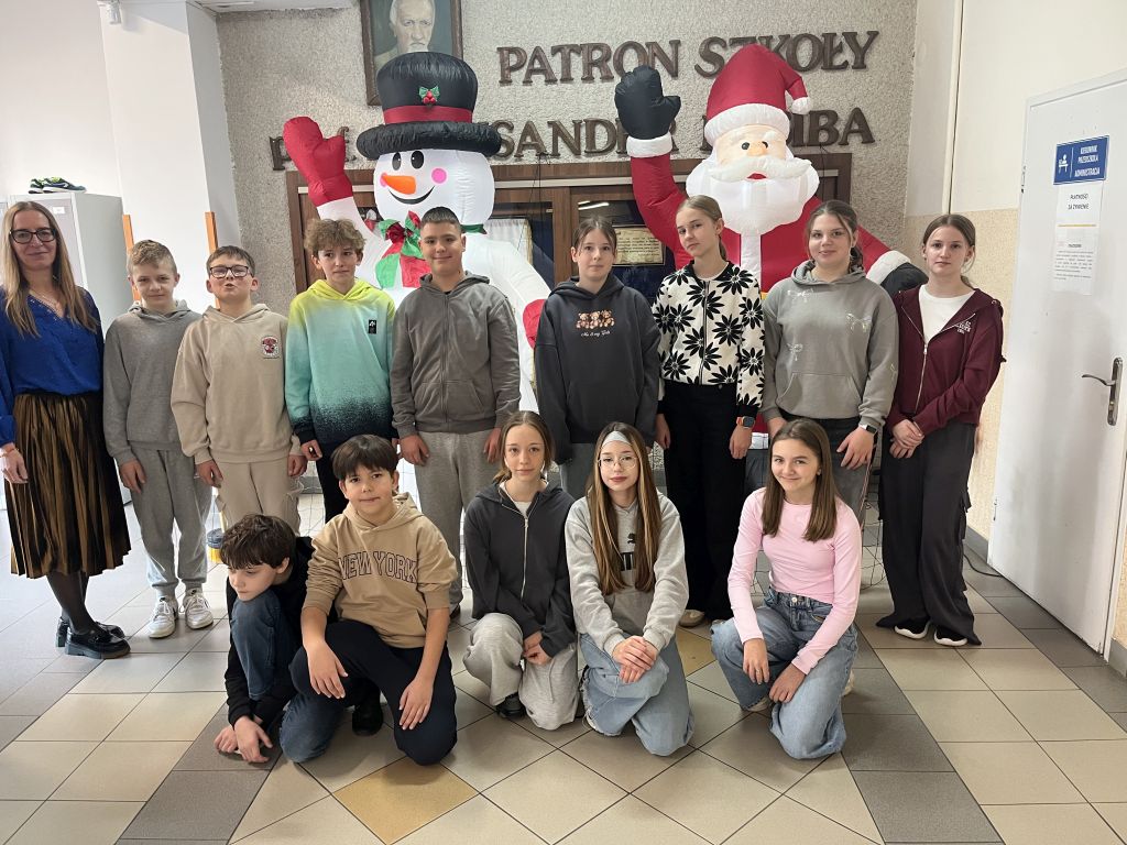 klasa 6b wraz z wychowawczynią stoją na korytarzu szkolnym - z tyłu dmuchany mikołaj i bałwan