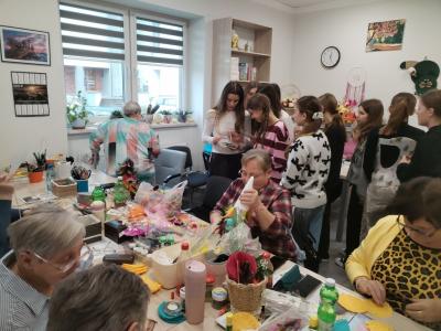 wolontariusze spędzają czas z seniorami, rozmawiają, robią ozdoby świąteczne.jpg