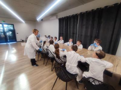 Dzieci biorą udział w warsztatach chemicznych