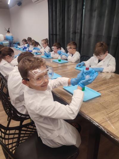 Dzieci biorą udział w warsztatach chemicznych