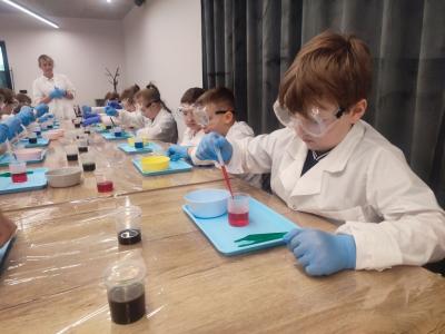 Dzieci biorą udział w warsztatach chemicznych
