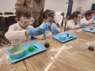 Dzieci biorą udział w warsztatach chemicznych