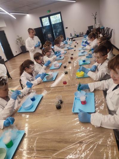 Dzieci biorą udział w warsztatach chemicznych