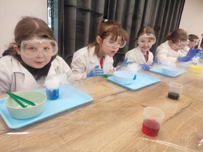 Dzieci biorą udział w warsztatach chemicznych