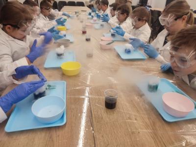 Dzieci biorą udział w warsztatach chemicznych