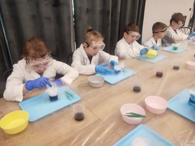 Dzieci biorą udział w warsztatach chemicznych