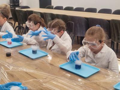 Dzieci biorą udział w warsztatach chemicznych