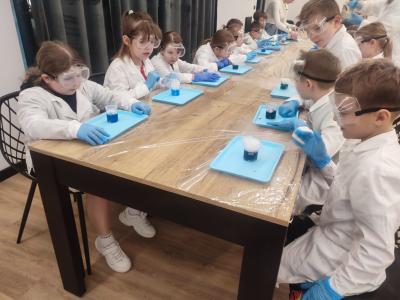 Dzieci biorą udział w warsztatach chemicznych