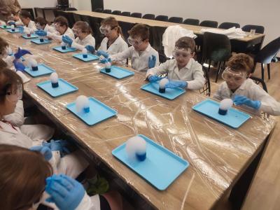 Dzieci biorą udział w warsztatach chemicznych