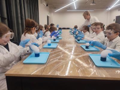 Dzieci biorą udział w warsztatach chemicznych