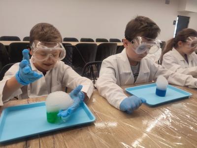 Dzieci biorą udział w warsztatach chemicznych